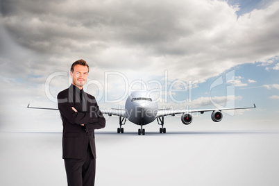 Composite image of handsome businessman with crossed arms