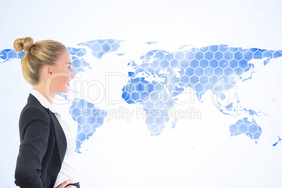 Composite image of businesswoman standing with hands on hips