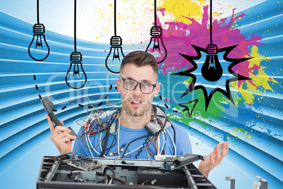 Composite image of confused it professional with cables and phon