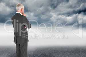 Composite image of thoughtful businessman standing back to camer