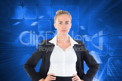 Composite image of businesswoman standing with hands on hips