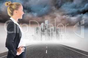 Composite image of businesswoman standing with hands on hips