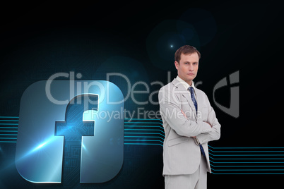 Composite image of serious businessman standing with his arms fo