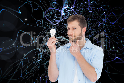 Composite image of handsome model holding a bulb