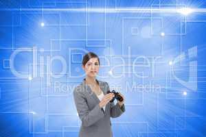 Composite image of curious young businesswoman posing with binoc