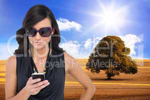 Composite image of happy brunette using smartphone