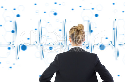 Composite image of businesswoman standing with hands on hips