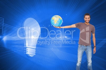 Composite image of handsome man holding out a globe