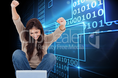 Composite image of brunette cheering while using laptop