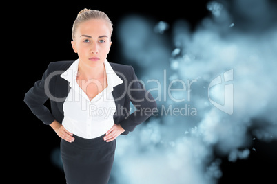 Composite image of businesswoman standing with hands on hips