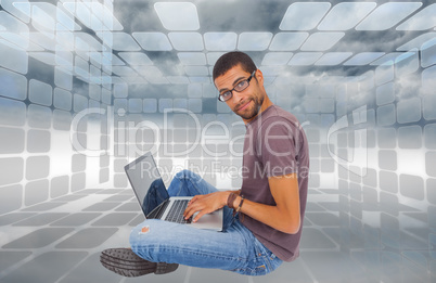 Composite image of man wearing glasses sitting on floor using la