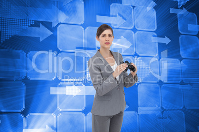 Composite image of curious young businesswoman posing with binoc