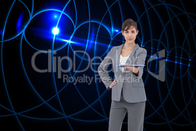 Composite image of attractive businesswoman holding tablet pc