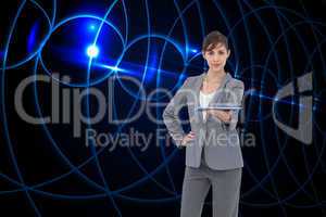 Composite image of attractive businesswoman holding tablet pc