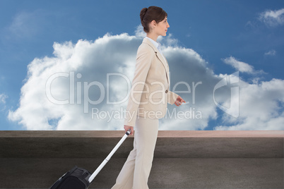 Composite image of serious businesswoman pulling suitcase