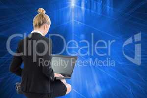 Composite image of businesswoman using laptop