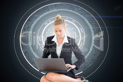 Composite image of businesswoman using laptop