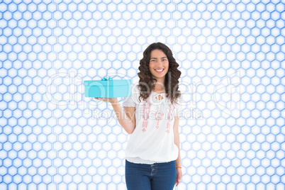 Composite image of content casual brunette holding a present