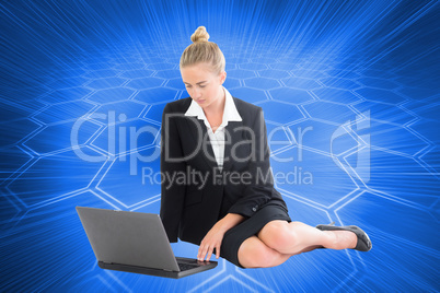 Composite image of businesswoman using laptop