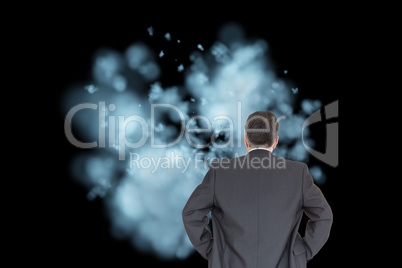 Composite image of businessman standing back to the camera with