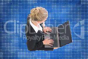 Composite image of businesswoman using laptop