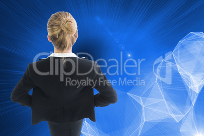 Composite image of businesswoman standing with hands on hips