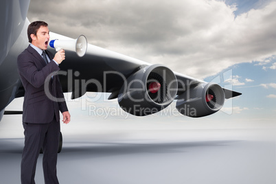 Composite image of standing businessman shouting through a megap