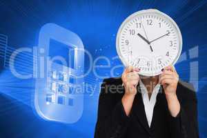 Composite image of businesswoman in suit holding a clock