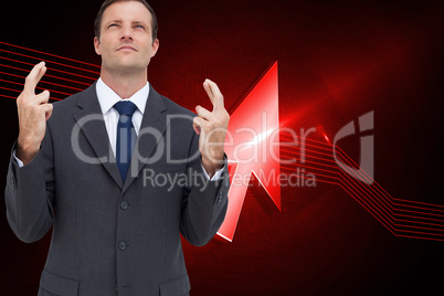 Composite image of serious businessman with fingers crossed is l