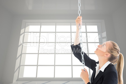 Composite image of businesswoman pulling a chain