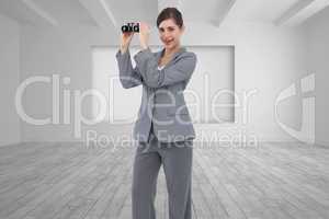 Composite image of businesswoman posing with binoculars