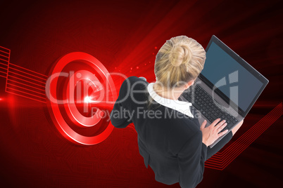 Composite image of businesswoman using laptop