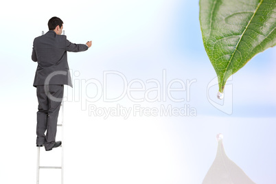 Composite image of businessman standing on ladder