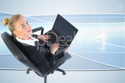 Composite image of businesswoman sitting on swivel chair with la