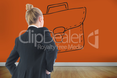 Composite image of businesswoman standing with hands on hips