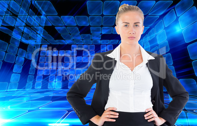 Composite image of businesswoman standing with hands on hips