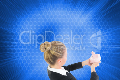 Composite image of businesswoman holding pink piggy bank