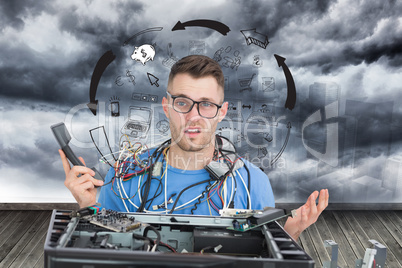 Composite image of confused it professional with cables and phon