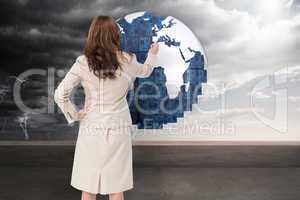 Composite image of businesswoman standing back to camera writing