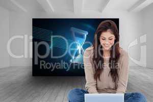 Composite image of brunette sitting on floor using laptop