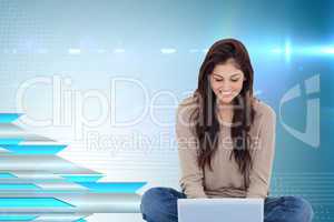 Composite image of brunette sitting on floor using laptop