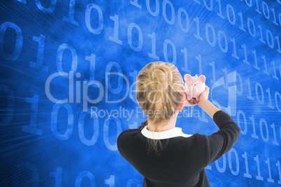 Composite image of businesswoman holding pink piggy bank