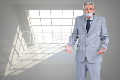 Composite image of businessman gagged with adhesive tape on mout