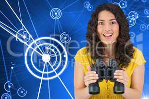 Composite image of smiling casual young woman holding binoculars