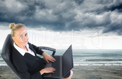 Composite image of businesswoman sitting on swivel chair with la