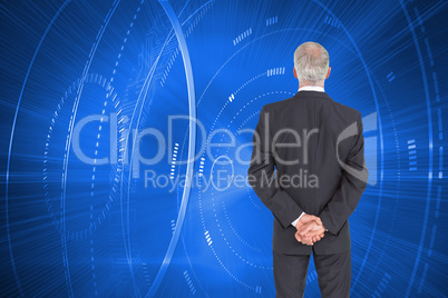 Composite image of rear view of serious businessman posing