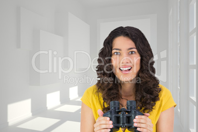 Composite image of smiling casual young woman holding binoculars