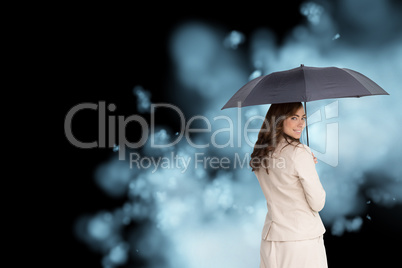 Composite image of rear view of classy businesswoman holding umb