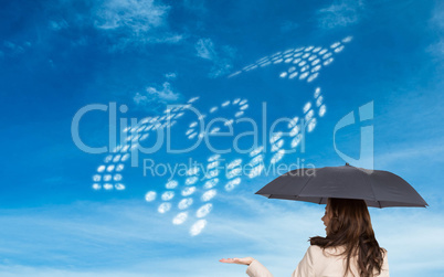 Composite image of elegant businesswoman holding black umbrella