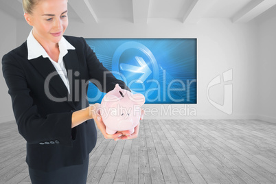 Composite image of businesswoman holding piggy bank